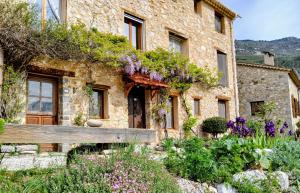 a stone house with flowers in front of it at Chambre des pierres, Cadre Magnifique au Cœur du Verdon in Castellane