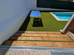 a blue table on the side of a house with a pool at VILLA Pinemar & Relax in Pineda de Mar