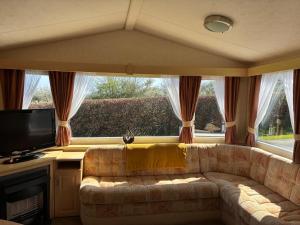 a living room with a couch in front of a window at Bardsey View Holiday Park Nr New Quay in Llanarth