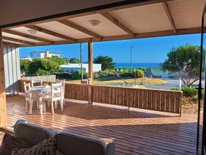 a patio with a table and chairs on a deck at Beach Walk by Salted Fynbos Staying in Pearly Beach