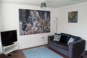 a living room with a couch and a tv at K Suites - Station Road 2 in Hinckley