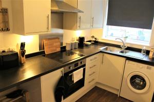a kitchen with a sink and a stove top oven at K Suites - Station Road 2 in Hinckley