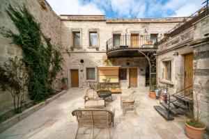 an outdoor patio with chairs and tables in an old building at Divan Cave House in Göreme