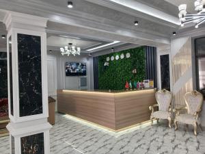 a lobby with a bar with a green wall at Safo Hotel Turkestan in Türkistan