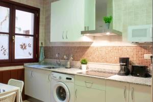a kitchen with a washing machine and a sink at Edificio Histórico en el Centro de Granada cerca de la Catedral y principales puntos de interés in Granada