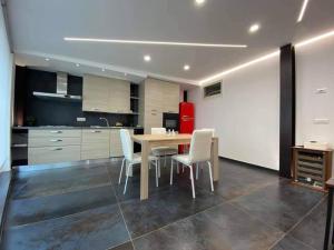 a kitchen with a dining room table and white chairs at Risorgimento House in Isernia