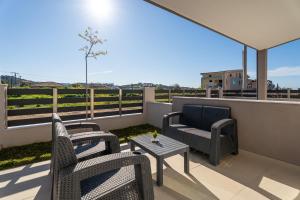 a patio with chairs and a table and a couch at ElGio Maisonette Nikiti in Nikiti