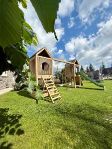 a playground with two playhouses in the grass at Novobilski przy Termie Bania i Kotelnicy - sauna, jacuzzi, restauracja, pokój zabaw, wypożyczalnia rowerów e-bike in Białka Tatrzańska +62 photos