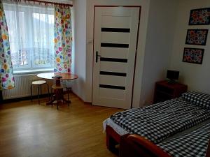 a bedroom with a bed and a table and a door at BERDO Noclegi i restauracja in Wetlina
