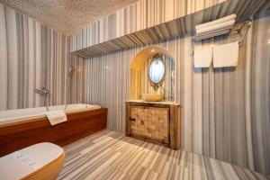 a bathroom with a tub and a toilet and a sink at Divan Cave House in Göreme +205 photos