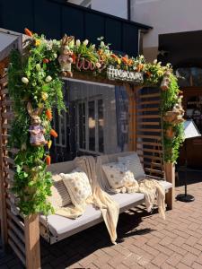 a gazebo with a bench and flowers on it at New Corner in Niechorze