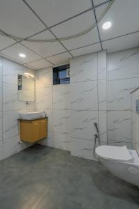 a bathroom with a sink and a toilet and a mirror at hotel monville akota in Vadodara +30 photos
