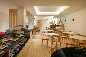 ein Restaurant mit Tischen und Stühlen und einem Buffet in der Unterkunft Hotel do Alboi in Aveiro