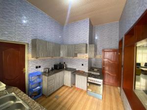 a large kitchen with wooden floors and blue walls at B-luxury stay in Ruhengeri