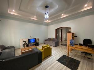 a living room with couches and a television and a table at B-luxury stay in Ruhengeri