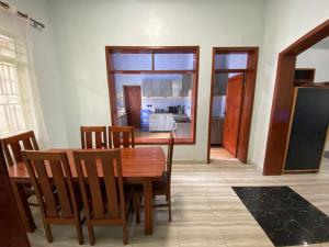 a dining room with a wooden table and chairs at B-luxury stay in Ruhengeri