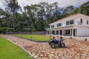 a home with a quad bike parked in front of it at Tusker Trails - A LuxUnlock Private Retreat in Suntikoppa +46 photos