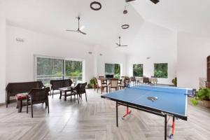 a pool table in a room with tables and chairs at Tusker Trails - A LuxUnlock Private Retreat in Suntikoppa