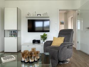 a living room with a chair and a tv at Diemelblick 22 - SEEBLICK in Heringhausen