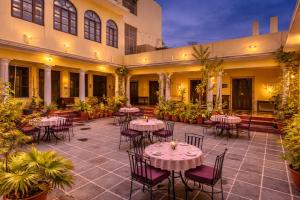 a courtyard with tables and chairs in a building at Kalyan Villa Heritage Stay in Udaipur