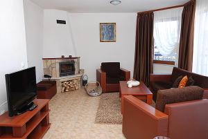 uma sala de estar com um sofá e uma televisão em Amampuri Village em Pamporovo