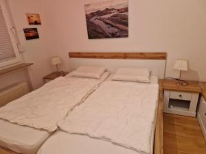 a bedroom with a large bed with white sheets at Nordseeperle in Hooksiel