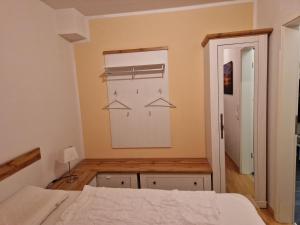 a bedroom with a bed and a closet with hangers at Nordseeperle in Hooksiel