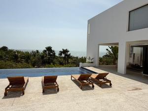 a group of chairs sitting next to a swimming pool at Maison des Alizés in Oussouye