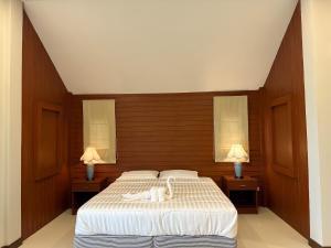 a bedroom with a bed with a white swan on it at Tsuya Hill Private Mountain View Villa, Chiang Rai in Mae Chan