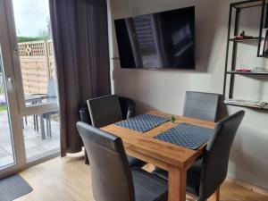 a dining room with a wooden table and chairs at Nordseeperle in Hooksiel