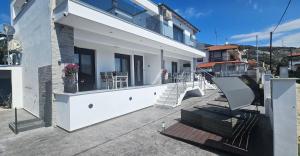 a balcony of a house with stairs and a chair at DaRo-Appartments in Asprovalta