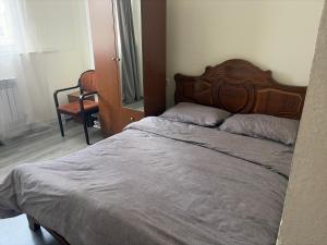 a bed with a wooden headboard in a bedroom at Republiq Apartment in City Ceneter in Yerevan