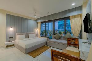 a living room with a couch and a large window at hotel monville akota in Vadodara