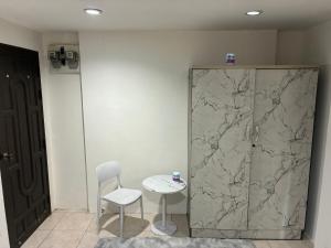 a table and a chair next to a marble wall at Farang house in Pattaya