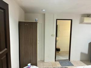a room with a bathroom with a door and a toilet at Farang house in Pattaya