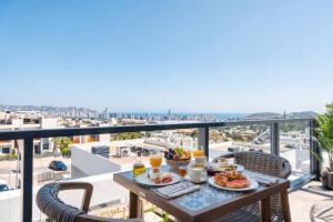 a table with food on a balcony with a view of the ocean at Stunning House, 3BR, HOT TUB, WIFI, Parking in Finestrat