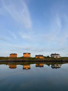 a group of houses on the shore of a body of water at Helligvær Kystopplevelser AS in Helligvær