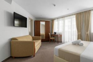 a hotel room with a bed and a couch and a desk at Alexandar Square Boutique Hotel in Skopje