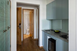 una cucina con mobili blu e un lavello di Hotel das Salinas by Alboi Group ad Aveiro Altre 60 foto