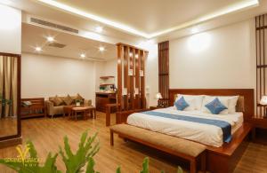 a hotel room with a bed and a couch at Spring Garden Hotel in Long Khanh