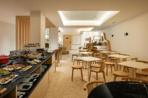 un ristorante con tavoli e sedie e un buffet di Hotel das Salinas by Alboi Group ad Aveiro