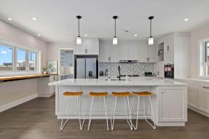 a kitchen with a large white island with bar stools at Charming 5-Bedroom House in Harrison