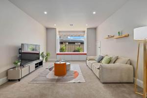 a living room with a couch and a tv at Charming 5-Bedroom House in Harrison