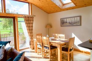 a dining room with a table and chairs at Plum Tree Lodge in Errol