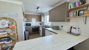 a kitchen with white marble counter tops and cabinets at F72 Chyreden, Riviere Towans in Hayle