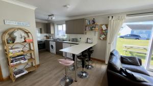a kitchen and living room with a table and a couch at F72 Chyreden, Riviere Towans in Hayle