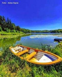 a wooden boat sitting on the shore of a lake at Domek nad jeziorem in Górzno
