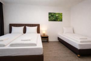 a bedroom with two beds and a table with a lamp at Hotel Hansahof Bremen in Bremen