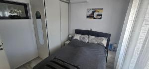 a small bedroom with a bed and a window at DaRo-Appartments in Asprovalta