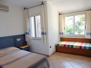 a bedroom with two beds and two windows at Residence la Chimera in Villasimius +34 photos